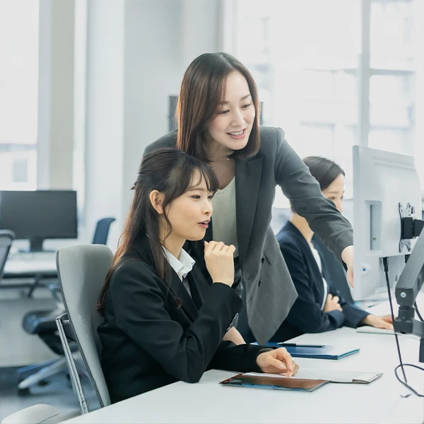 学生インターンに女性社員が仕事を教えている